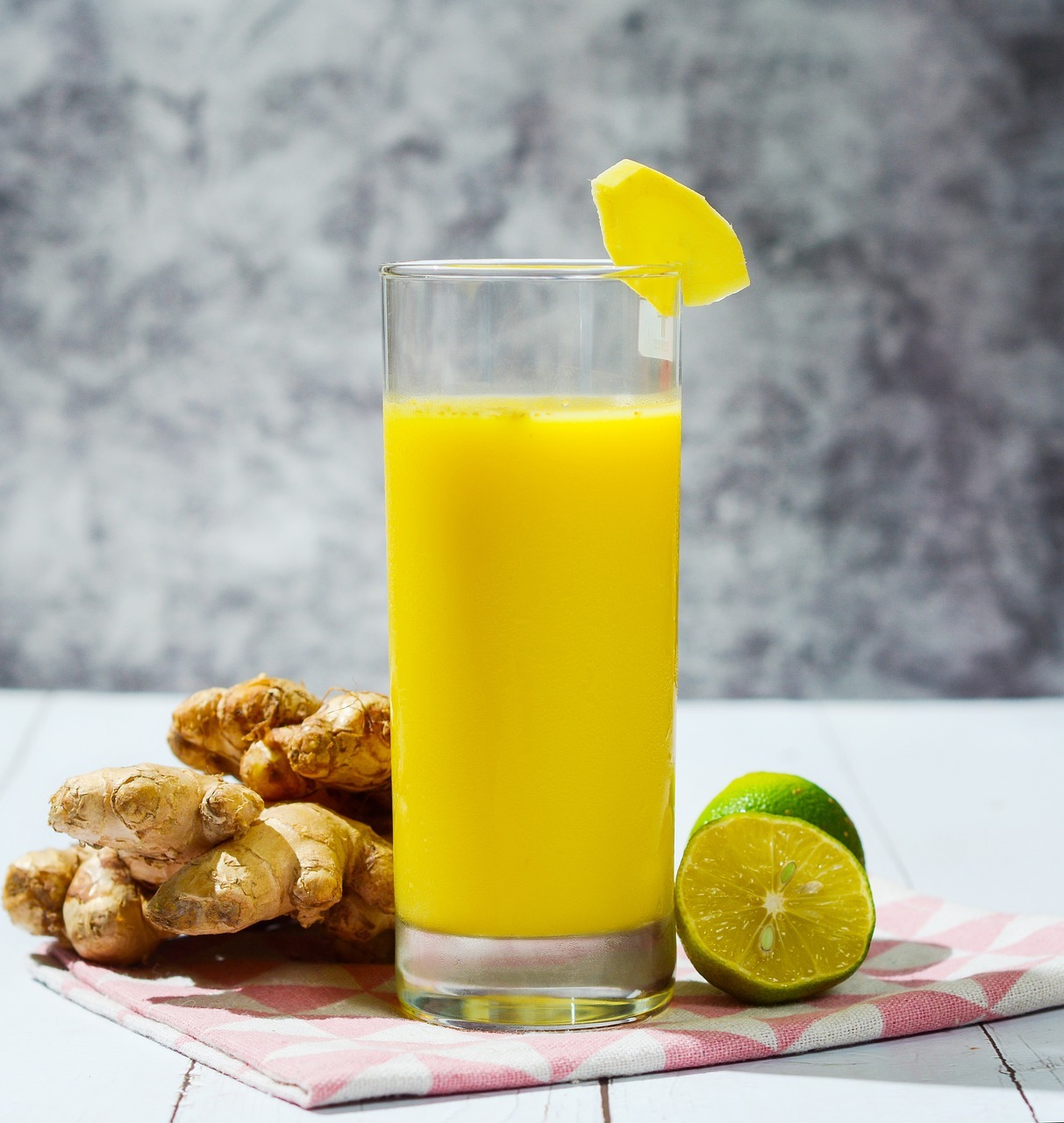 A glass of orange juice next to a lemon and ginger
AI-generated content may be incorrect.