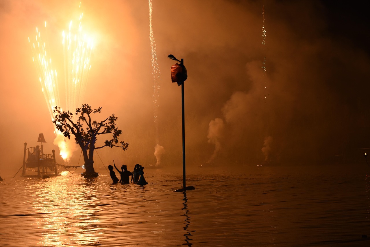 A group of people in water with fireworks
AI-generated content may be incorrect.