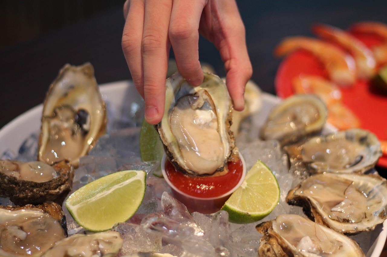 A hand holding a oyster over a platter of ice
AI-generated content may be incorrect.