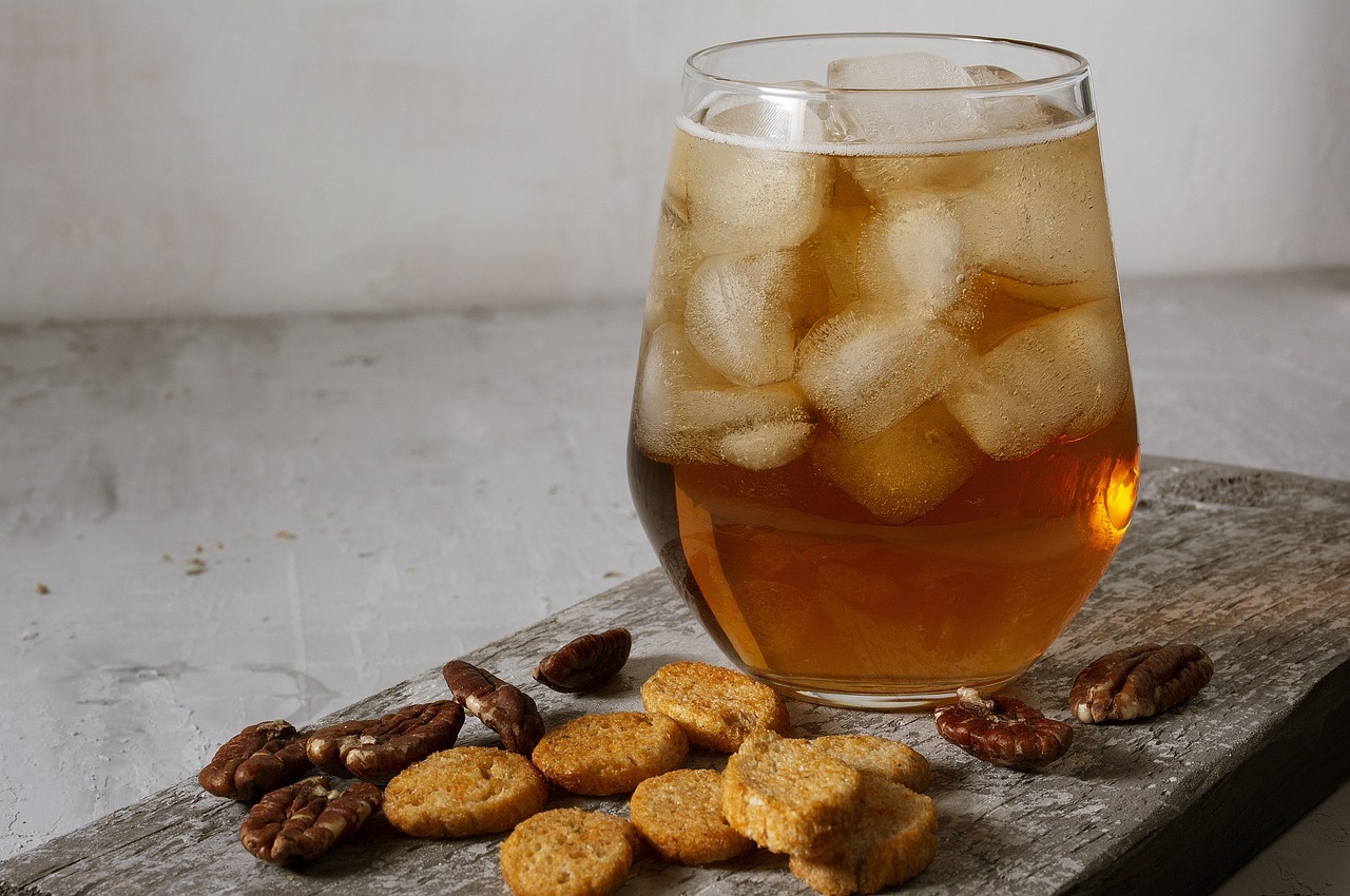 A glass of ice tea with crackers and nuts

AI-generated content may be incorrect.