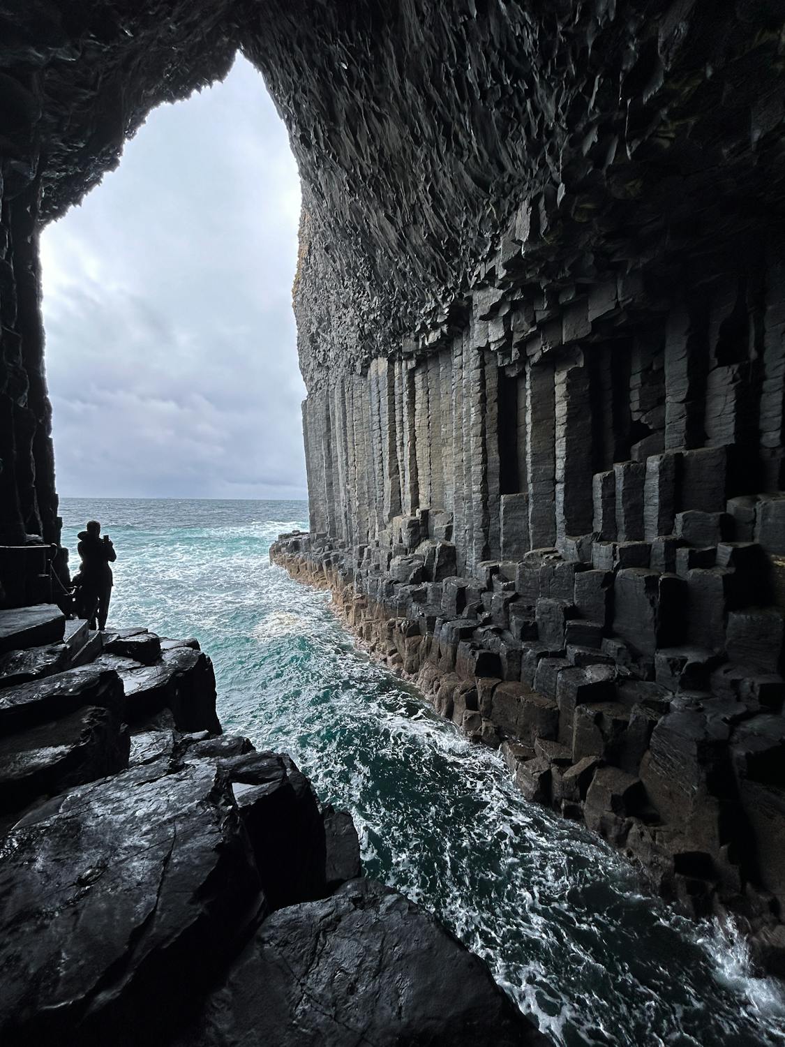 A person standing on a rock cliff

AI-generated content may be incorrect.