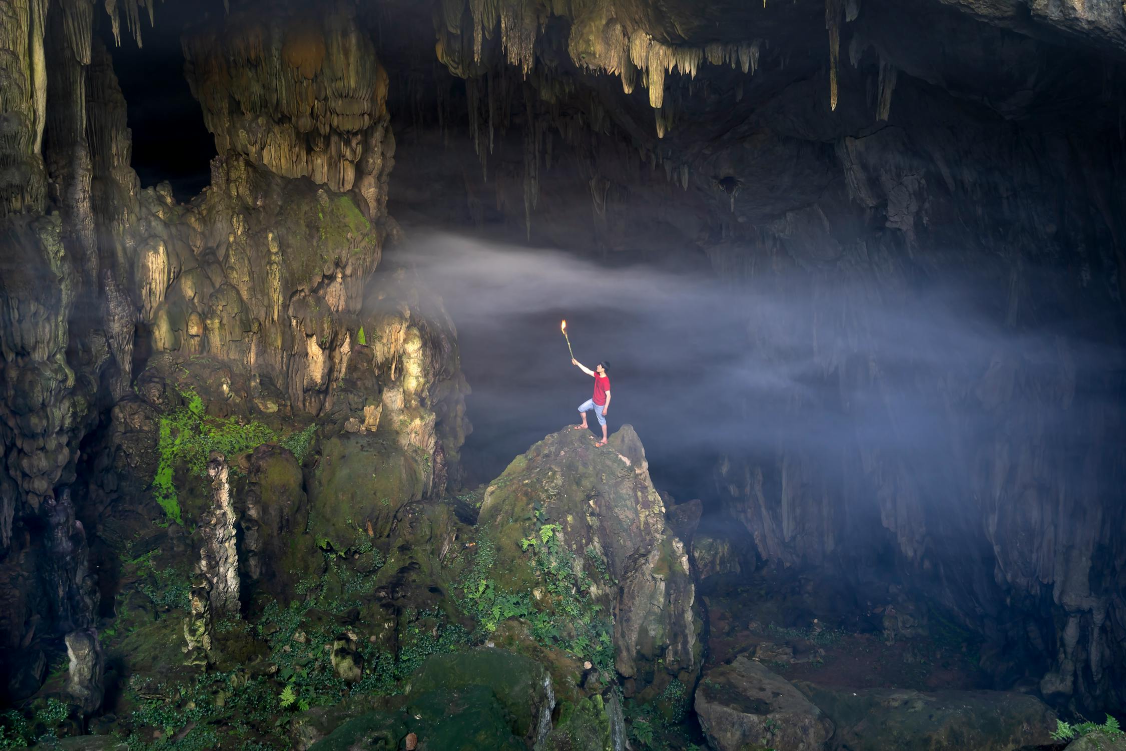 A person standing on a rock in a cave

AI-generated content may be incorrect.